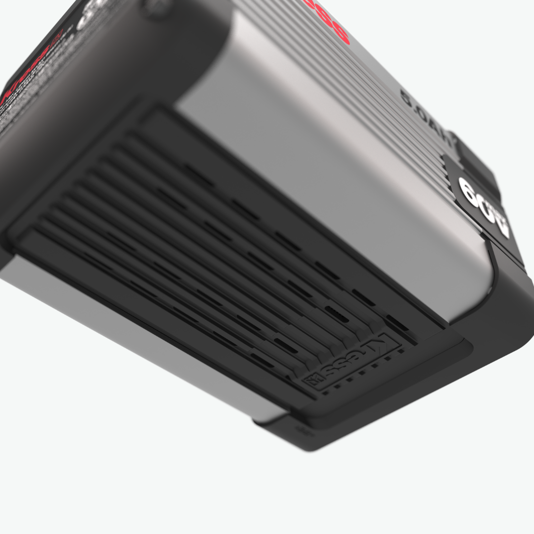 Close-up of a black and silver Kress Battery, showing a ribbed metallic top panel, a black vented lower section, and a white '60V' logo on the side against a light gray background.