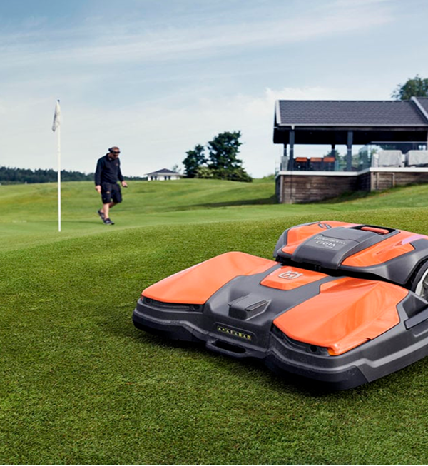 Husqvarna Automower CEORA on the golf course with the man on the background